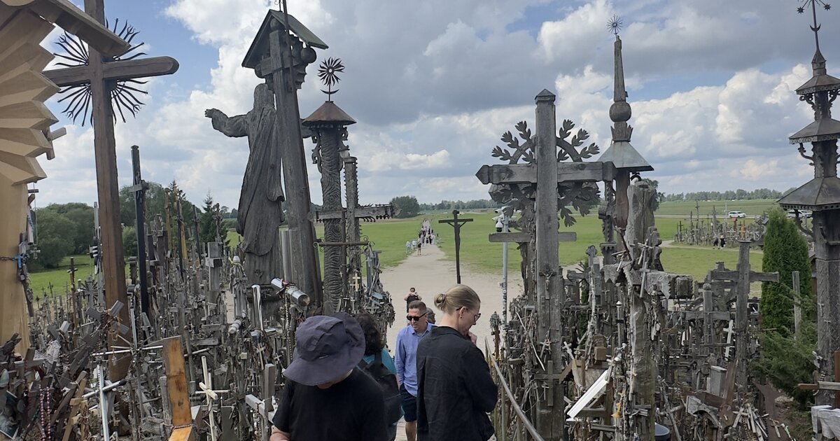 Berg der Kreuze, Litauen — Holzsteg mit Jesus-Statue und handgeschnitzten Kreuzen.