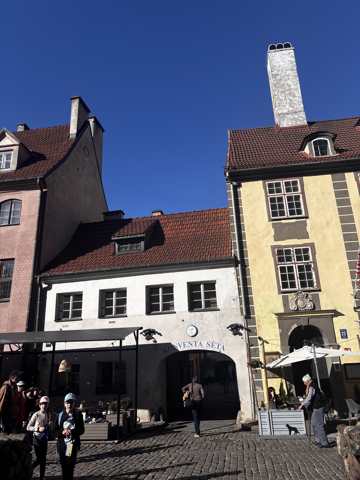 Der gew&ouml;lbte Eingang von Konventa Sēta von der Kalēju iela aus, in der Rigaer Altstadt, Lettland, mit dem &lsquo;KONVENTA SĒTA&rsquo;-Schild &uuml;ber dem Bogen.