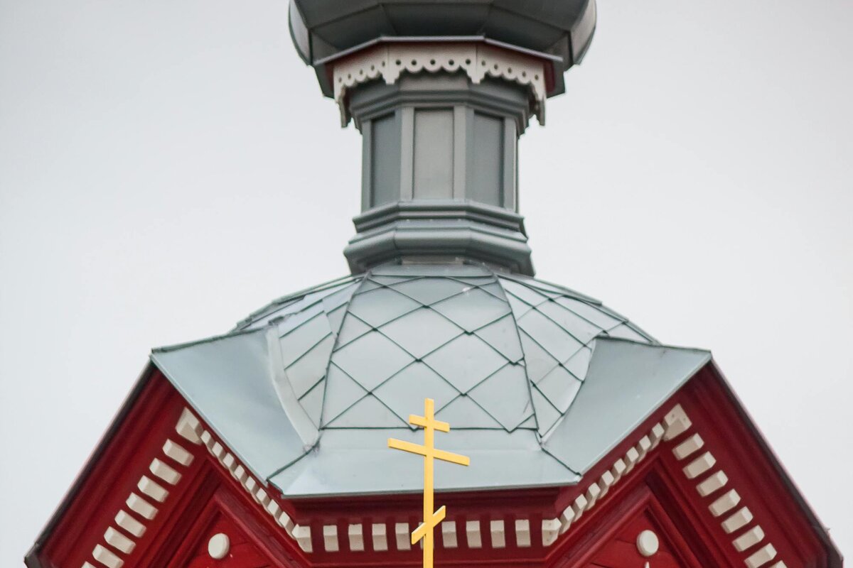Eine hölzerne orthodoxe Kirche mit Zwiebelturm und dem dreibalkigen orthodoxen Kreuz — Lettland.