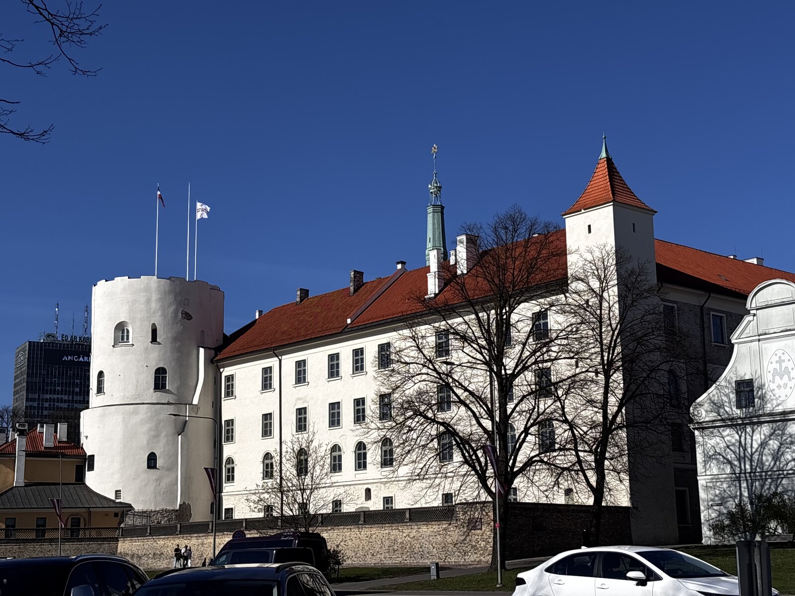 Die Rigaer Burg (Rīgas pils) mit ihren wei&szlig;en Mauern, dem roten Dach und dem runden Heilig-Geist-Turm in Riga, Lettland.