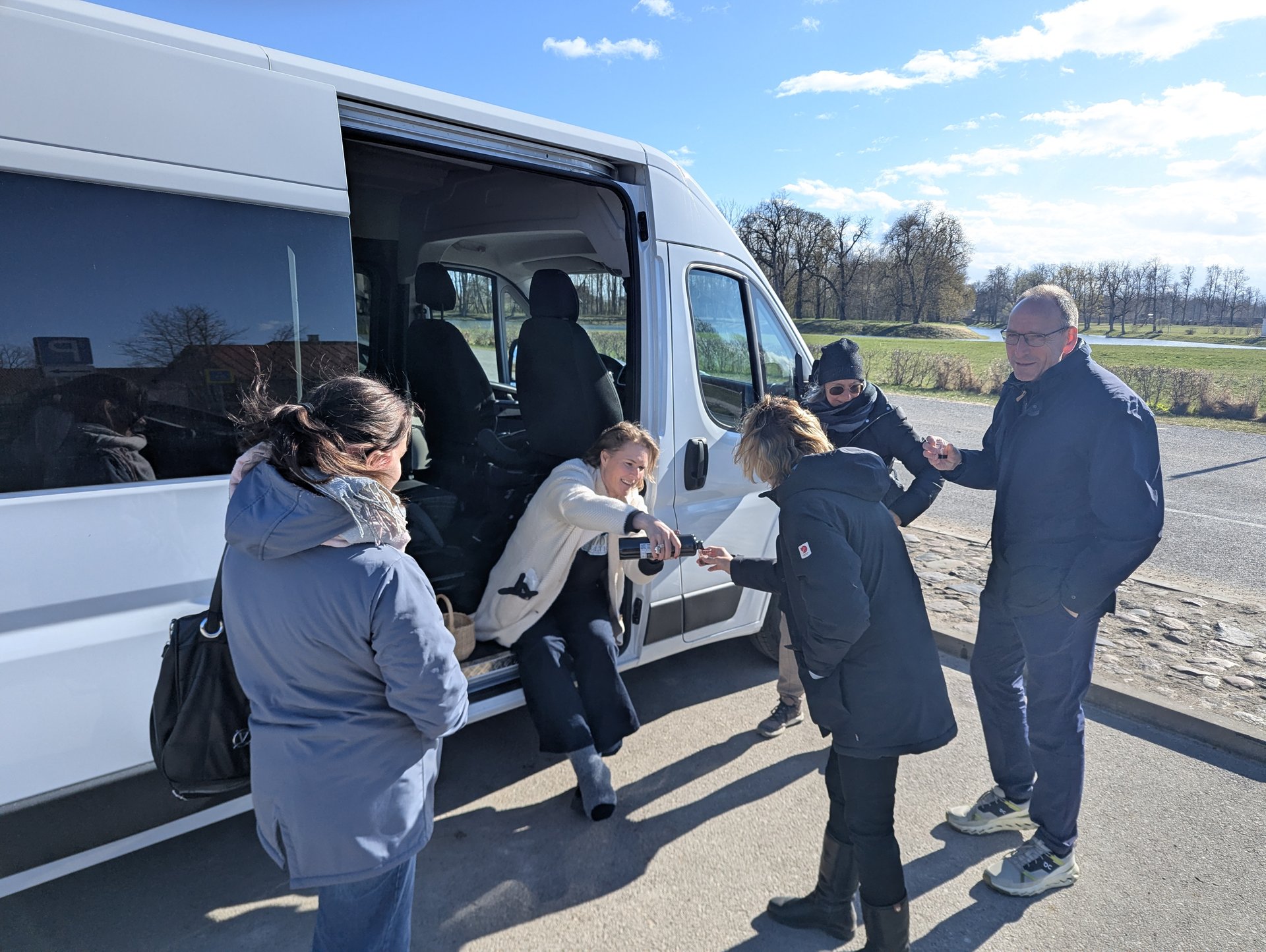 Daiga reicht eine Verkostung an der Seitentür des Barefoot-Baltic-Kleinbusses