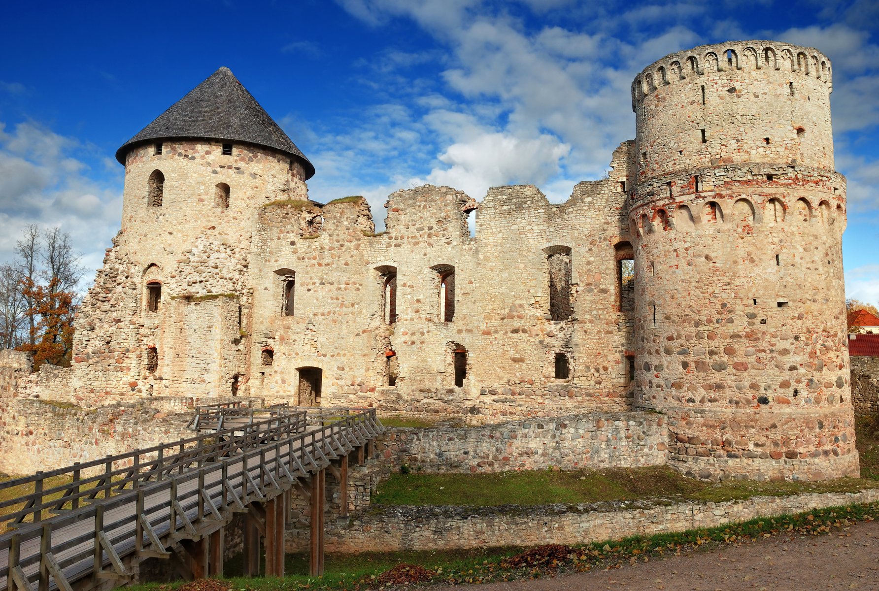 Die rotwandigen Türme der Burg Cēsis unter blauem Himmel