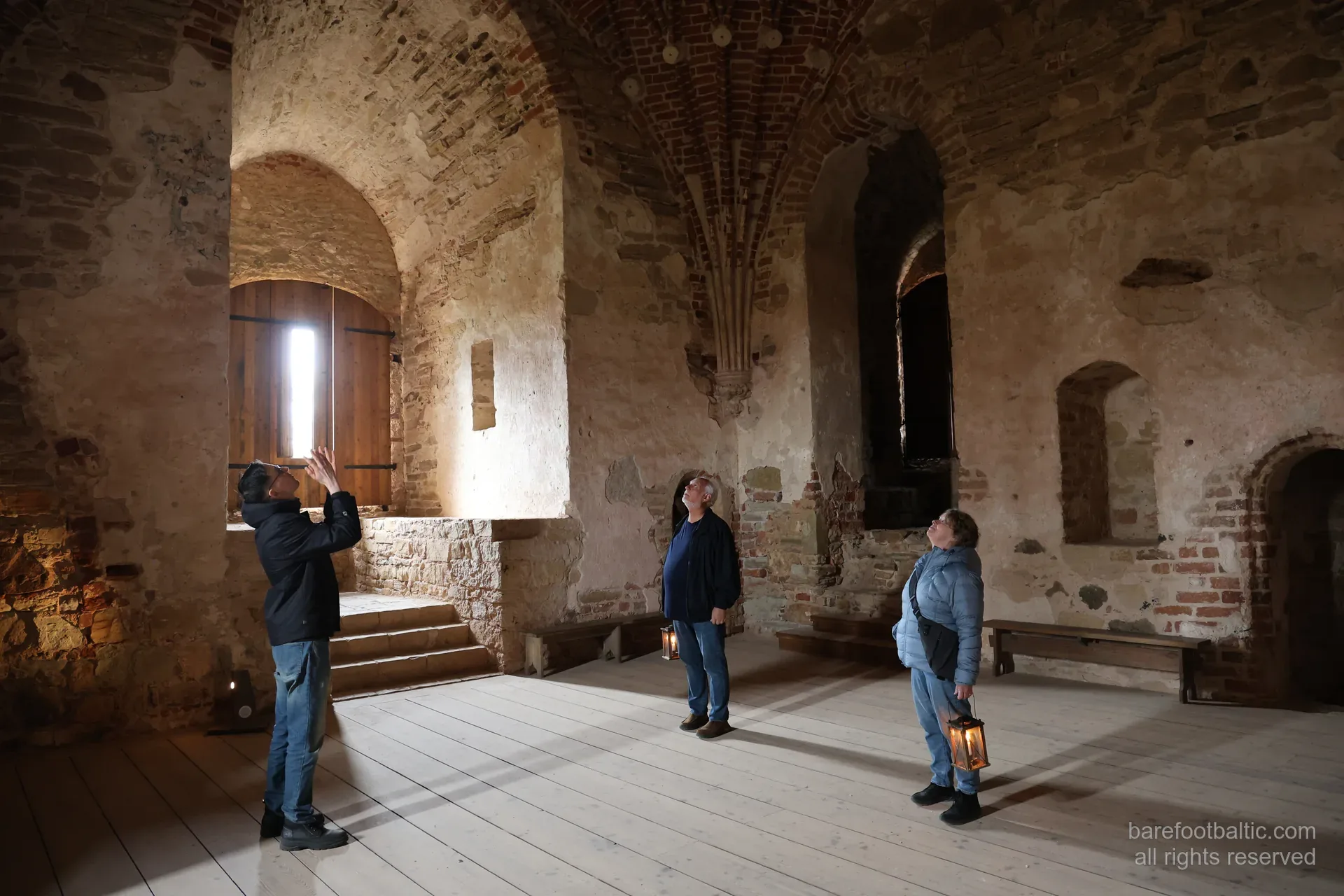 Gäste mit Kerzenlaternen im Inneren der Mittelalterlichen Burg Cēsis