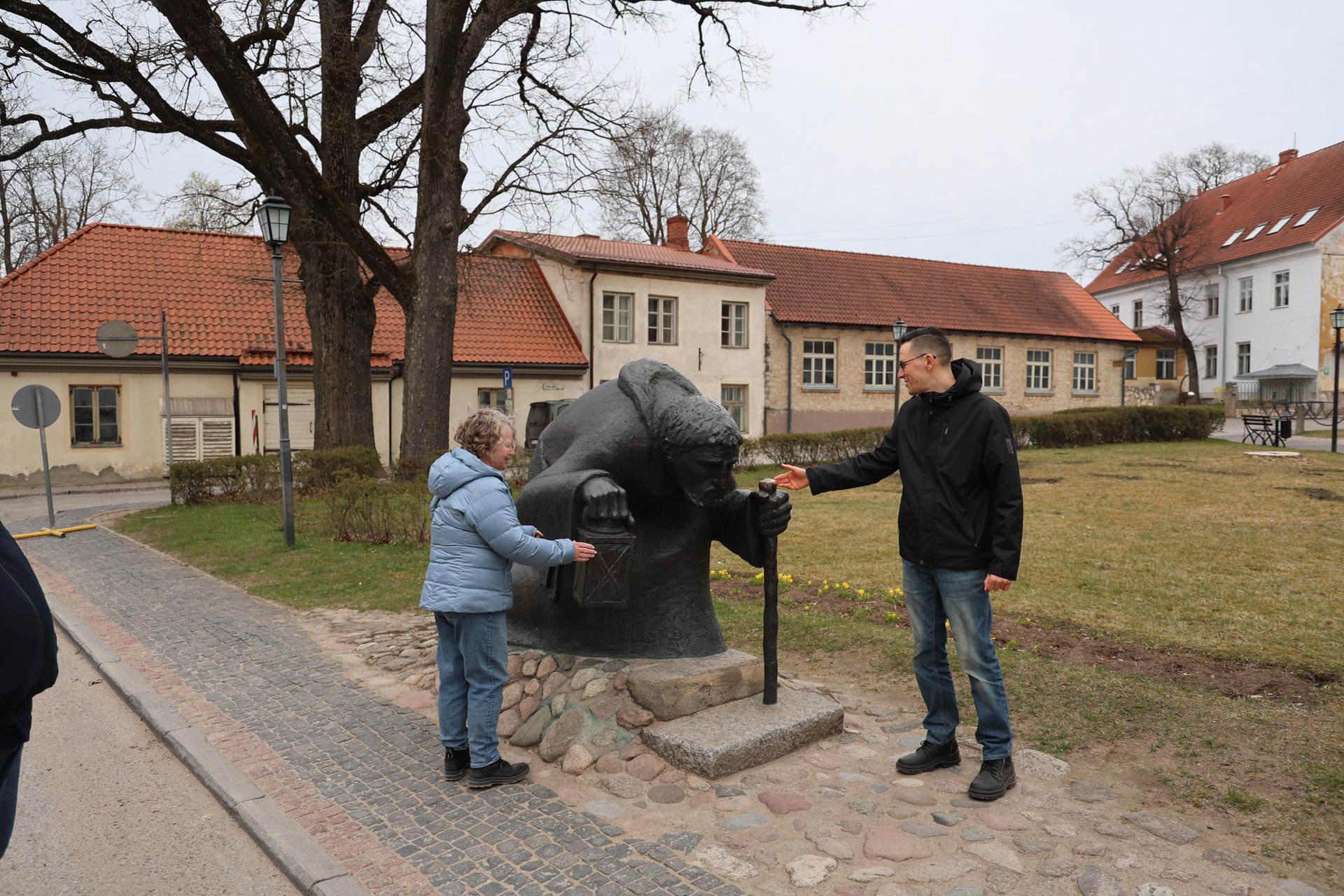 Reisegruppe an der Bronzeskulptur des Pilgers im Altstadtpark von Cēsis