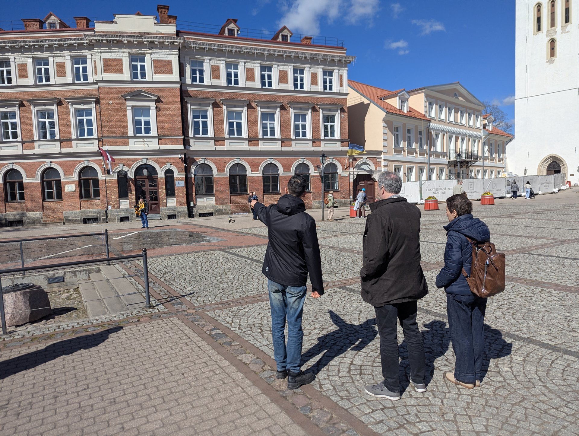 Stadtführung durch die Altstadt von Cēsis, Reiseleiterin zeigt ein historisches Gebäude