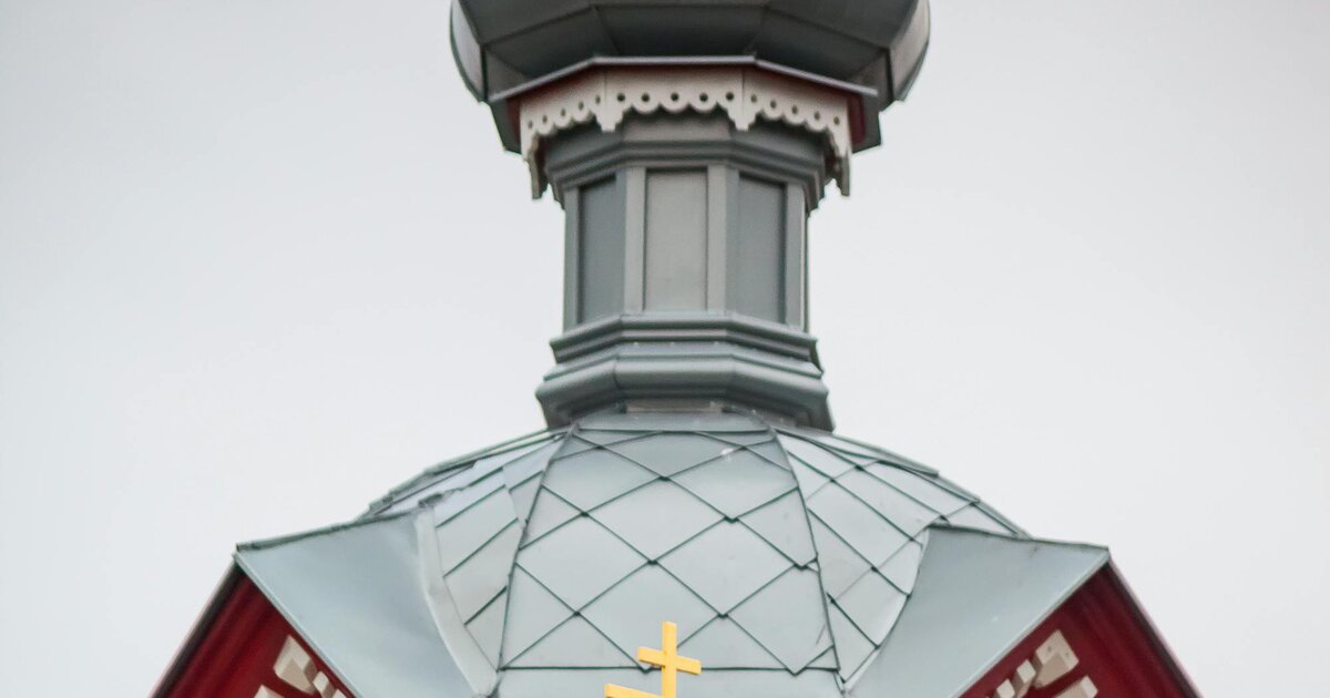 Eine hölzerne orthodoxe Kirche mit Zwiebelturm und dem dreibalkigen orthodoxen Kreuz — Lettland.